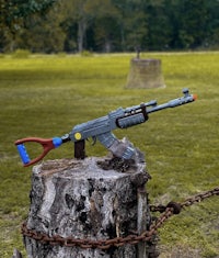 a toy rifle sits on top of a tree stump